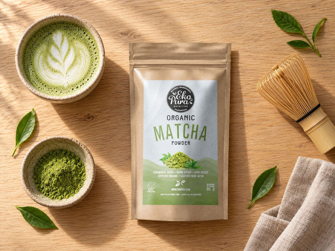 Matcha latte con schiuma di latte, accanto a Ekopura Matcha in polvere biologico, una ciotolina di matcha e una frusta di bambù